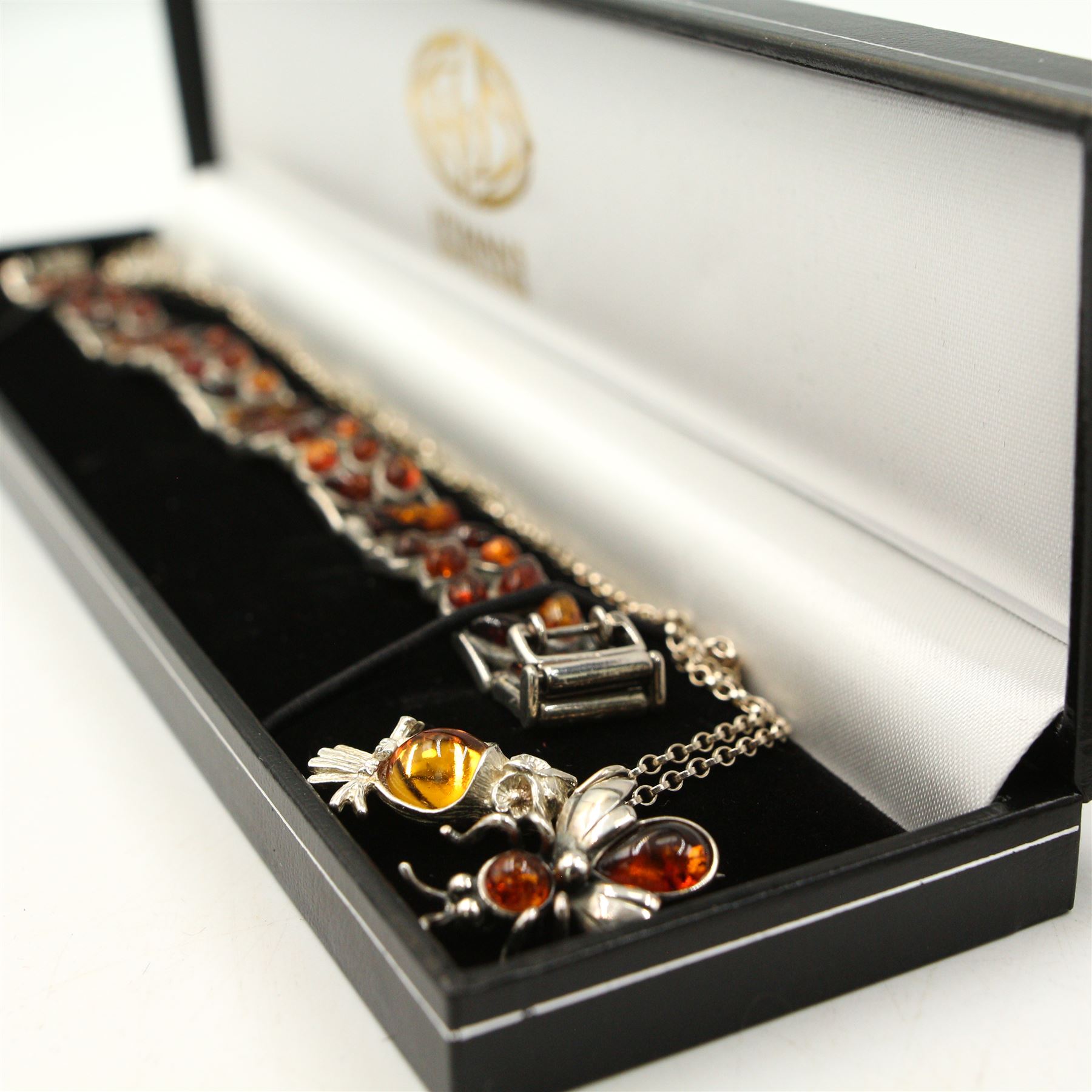 Group of silver amber jewellery, including three amber pendant necklaces, an amber bracelet, amber brooch and two amber rings