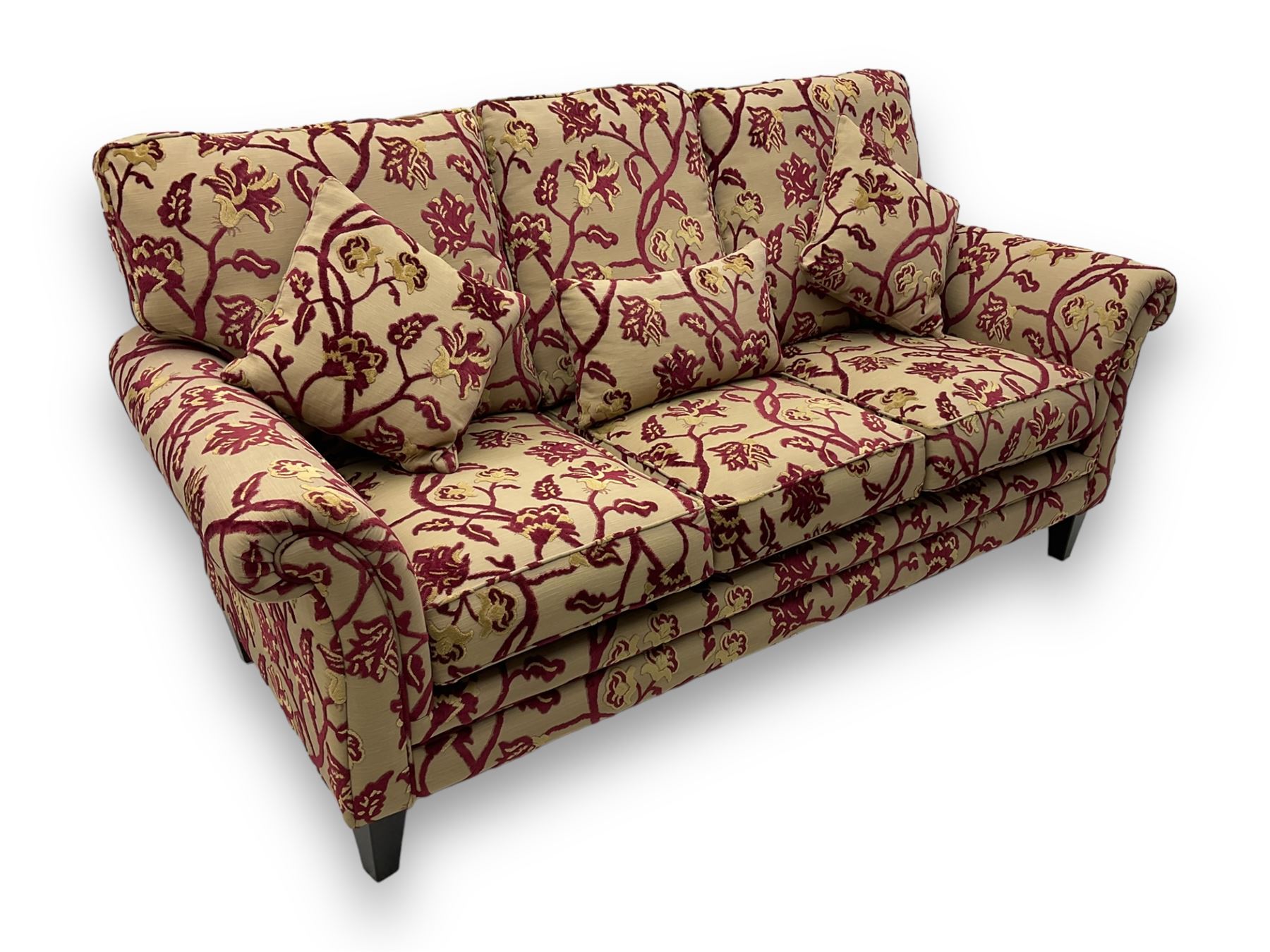 Contemporary upholstered three-seat sofa, scroll arms and loose cushions, embossed beige ground fabric with red and gold floral motifs, on tapered wooden supports