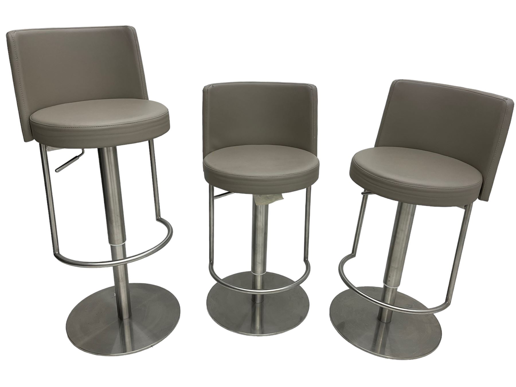 Three contemporary polished metal adjustable Monza bar stools, with taupe faux leather upholstered seats, supported by a brushed stainless steel pedestal base with integrated footrests