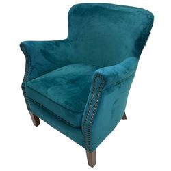 Contemporary tub-shaped armchair, upholstered in teal blue fabric, with high back and rolled arms accented with brass studded trim, on square tapered front feet