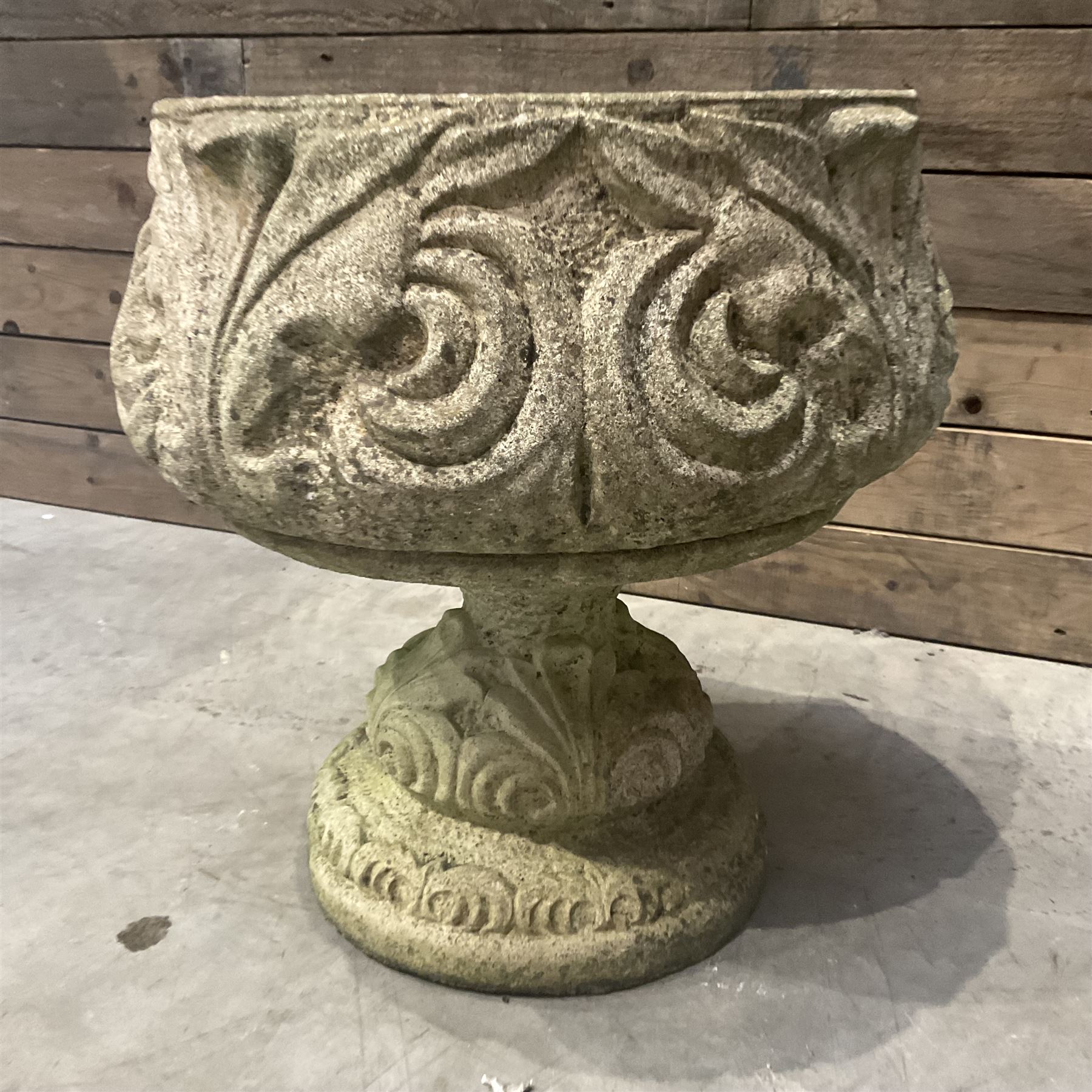 Cast stone circular garden urn decorated with scrolling foliate relief pattern