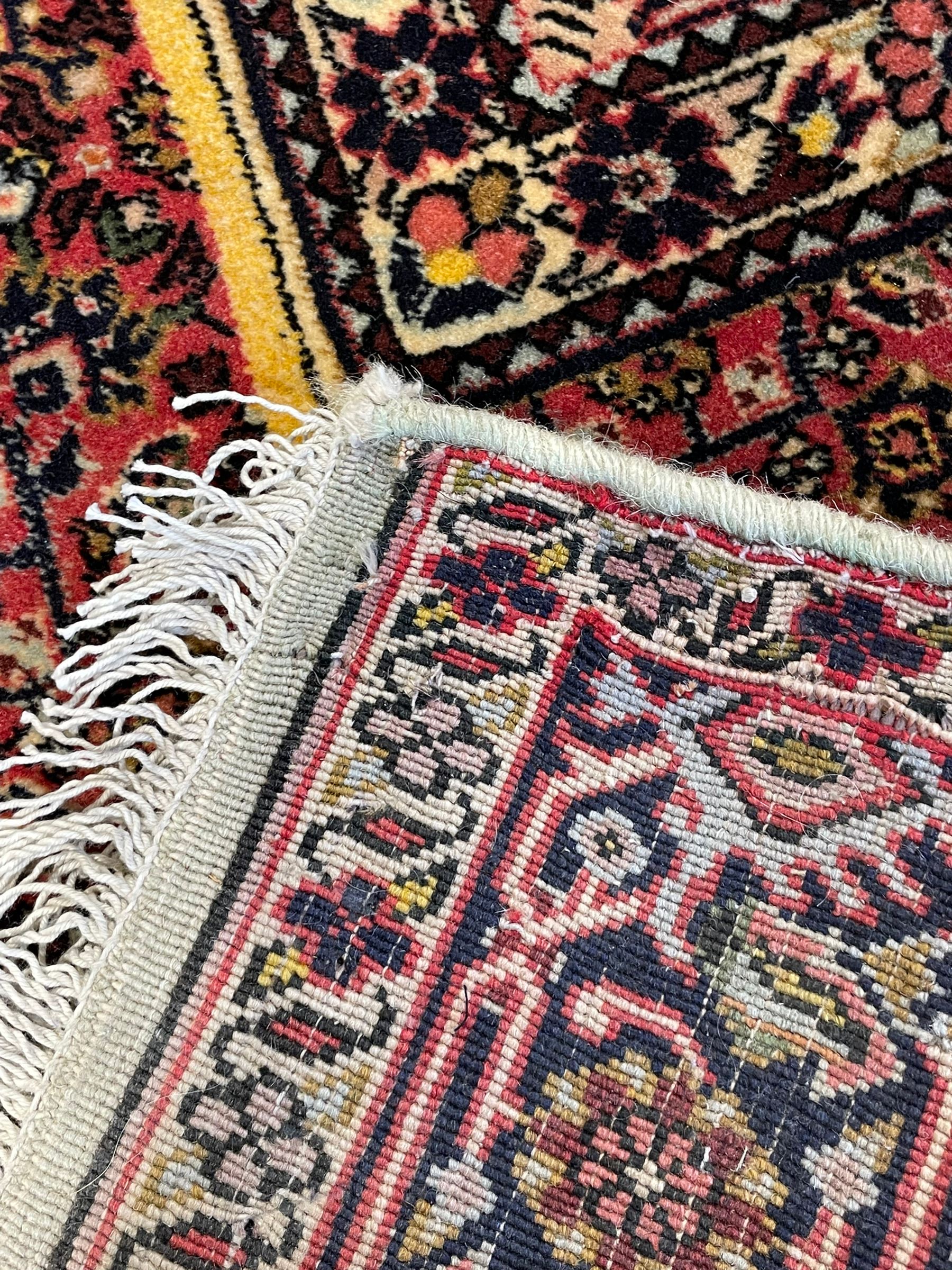 Persian Bidjar peach ground rug, the field decorated with repeating Herati motifs surrounding an off-centre lozenge medallion, decorated with grazing deer and peacock motids, the field border decorated with repeating stylised plant motifs, multiple floral design guard bands