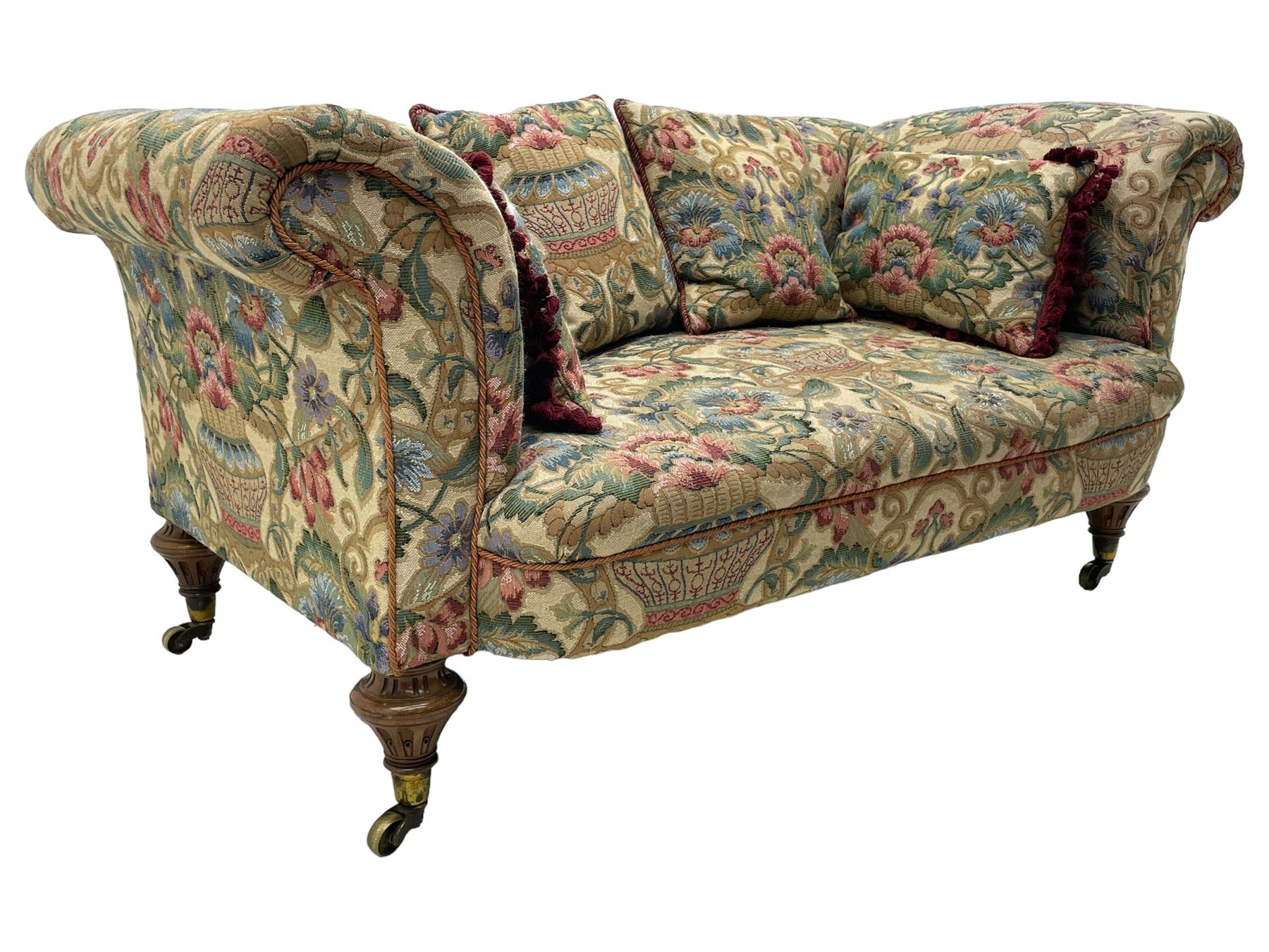 Mid-19th century walnut framed two-seat sofa, rolled arms over sprung seat, single drop-end action, raised on turned and fluted feet with brass cups and castors, upholstered by E & S Gott in traditional floral pattern fabric decorated with urns