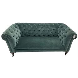 Victorian hardwood-framed Chesterfield sofa, traditional shape with low back and rolled arms, upholstered in teal buttoned fabric, on turned front feet with brass and ceramic castors 