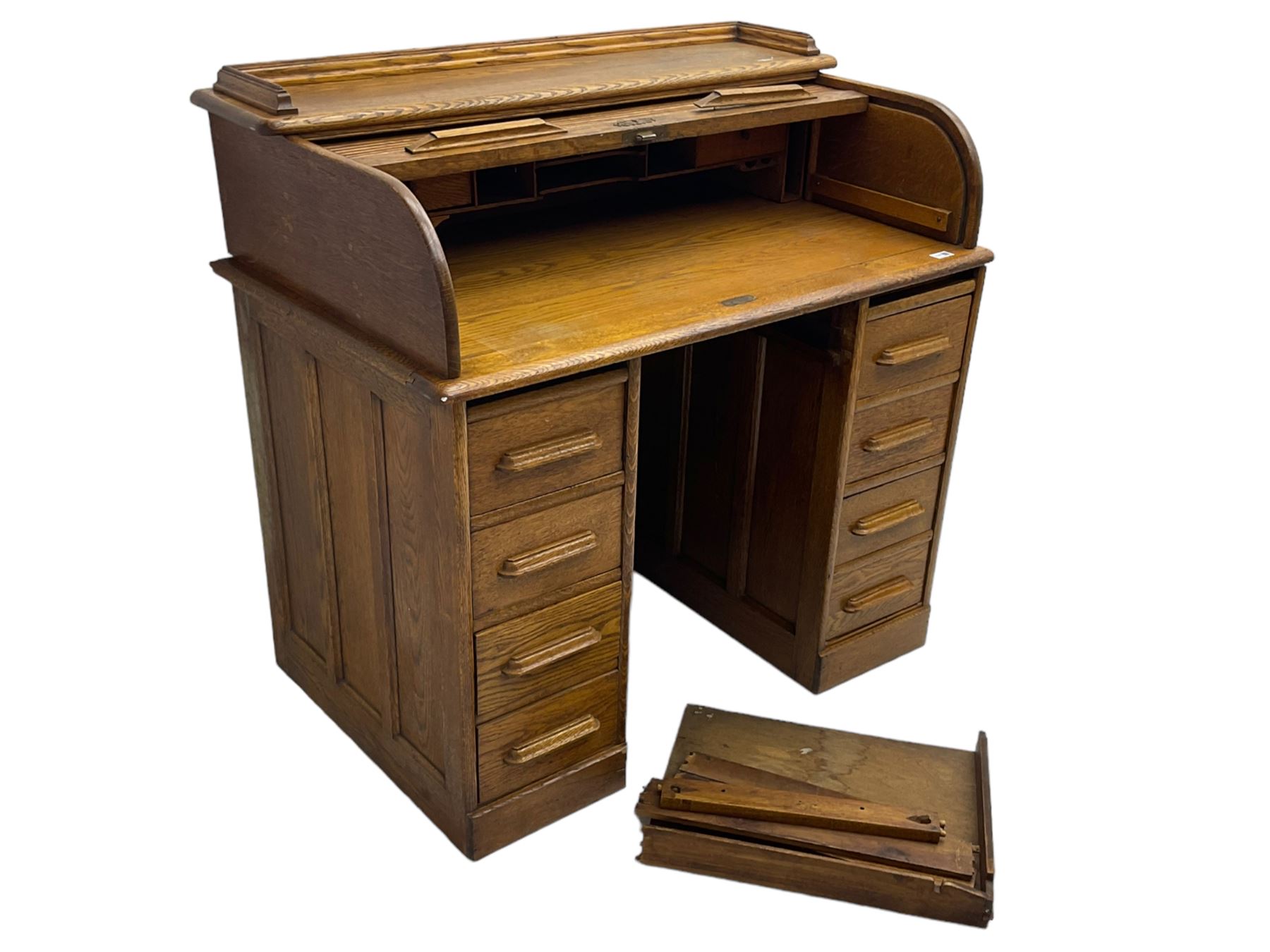 Early 20th century oak twin pedestal desk, tambour roll top enclosing fitted interior, eight drawers, on plinth base