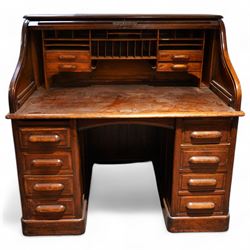 Early 20th century oak twin pedestal roll top desk, tambour roll enclosing small drawers a...