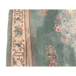 Chinese pale turquoise ground washed woolen rug, oval form decorated with bouquets of floral designs and Chinese characters, enclosed by a wide guard band