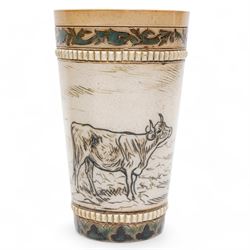 Late 19th century Doulton Lambeth sgraffito jug and beaker by Hannah Barlow, decorated with bands of cattle in landscapes between foliate boarders, with impressed and incised marks beneath, including monogram H24cm (2)