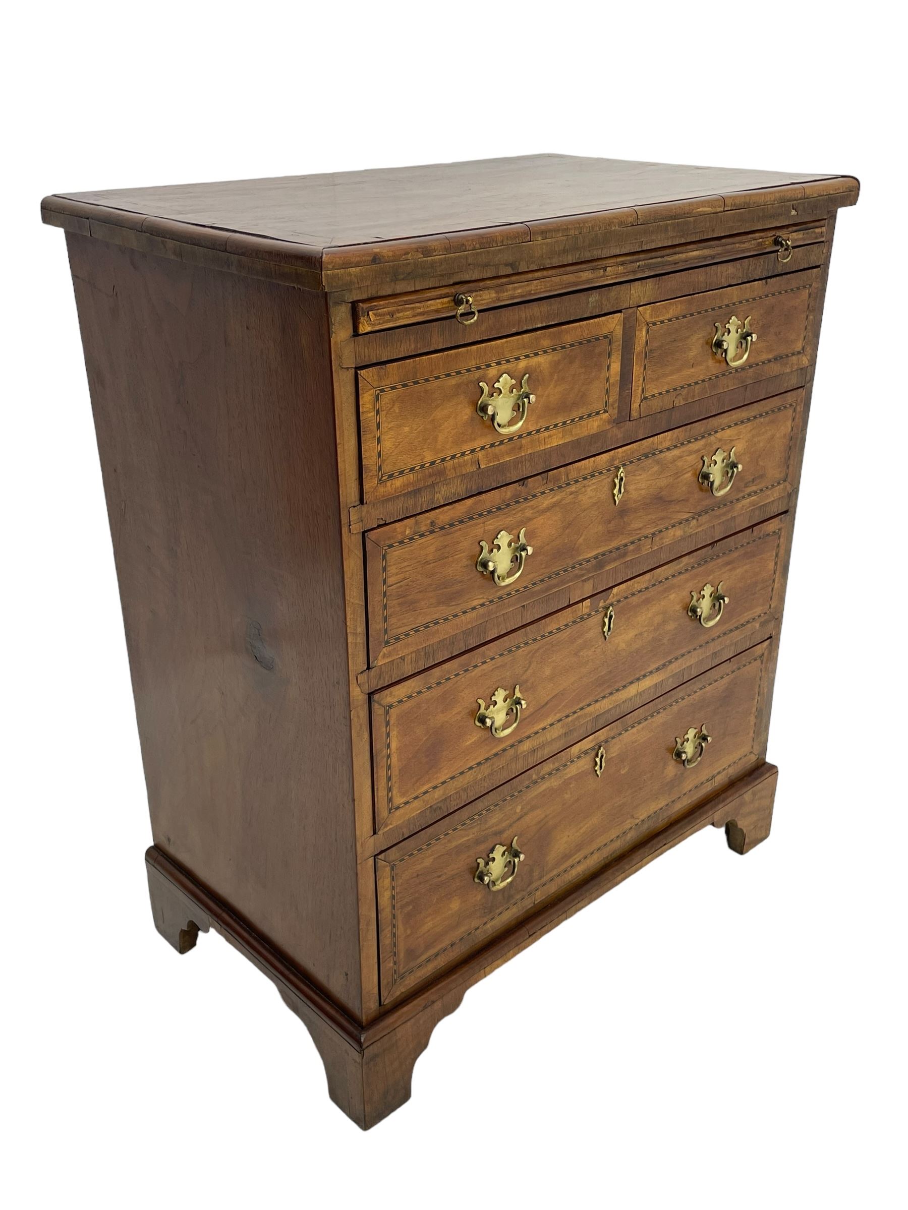 Small Georgian design walnut chest, moulded rectangular top with book-matched veneer enclosed by checkered stringing and crossbanding, brushing slide over two short and three long drawer, on bracket feet