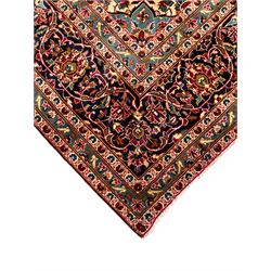 Persian Kashan crimson ground carpet, floral pattern pole medallion surrounded by trailing branches with foliate motifs and palmettes, scrolling border decorated with stylised plant motifs, within multiple guard stripes