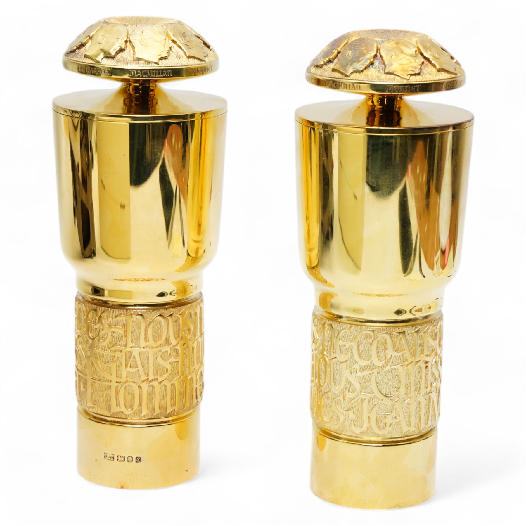 Pair of limited edition silver gilt 'The Congress of Europe Standing Cups and Covers', commemorating Jean Monnet's services to the cause of European Unity, designed by Hector Miller and Madeleine Dinkel for Aurum, the lids bearing carved portraits of eight statesmen including Adenhauer, Churchill, Macmillan and others, the bands of calligraphy in high relief quoting Monnet, no. 37 and 36/100, hallmarked Aurum, London 1973, H21cm, with certificates and original case