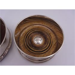 Two modern silver mounted bottle coasters, each with a turned wooden centre, both hallmarked WW, London 1988 & 1996, largest example D12.5cm