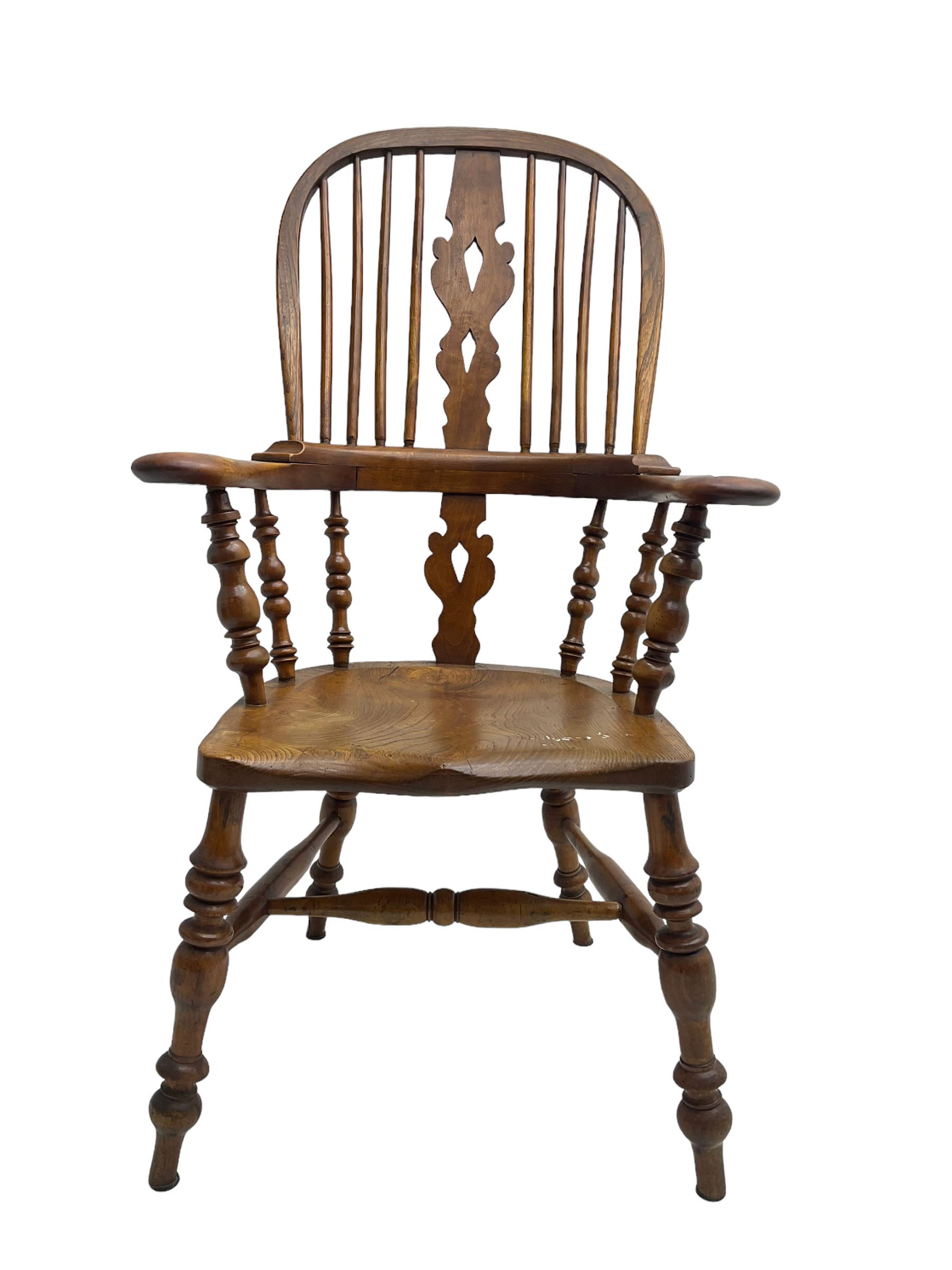 Elm and beech high back Windsor chair,  high hoop back with pierced splat and spindle supports over shaped saddle seat, raised on ring turned supports united by H-stretcher