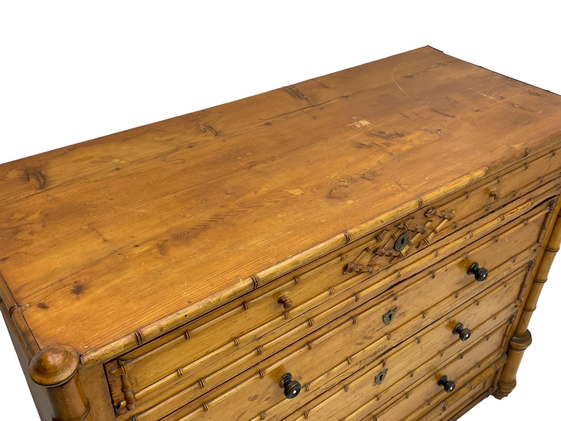 Victorian pine and simulated bamboo chest, fitted with five drawers, the drawer fronts decorated with applied simulated bamboo mounts and turned ebonised handles, on turned front feet