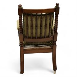 Late Victorian walnut bobbin turned armchair, curved cresting rail with bead moulding over turned spindle back, upholstered arms on turned balustrade supports, cane work seat over seat rail with matching bead moulding, loose seat cushion upholstered in olive green fabric, on tapering bobbin turned front supports with brass and ceramic castors, 