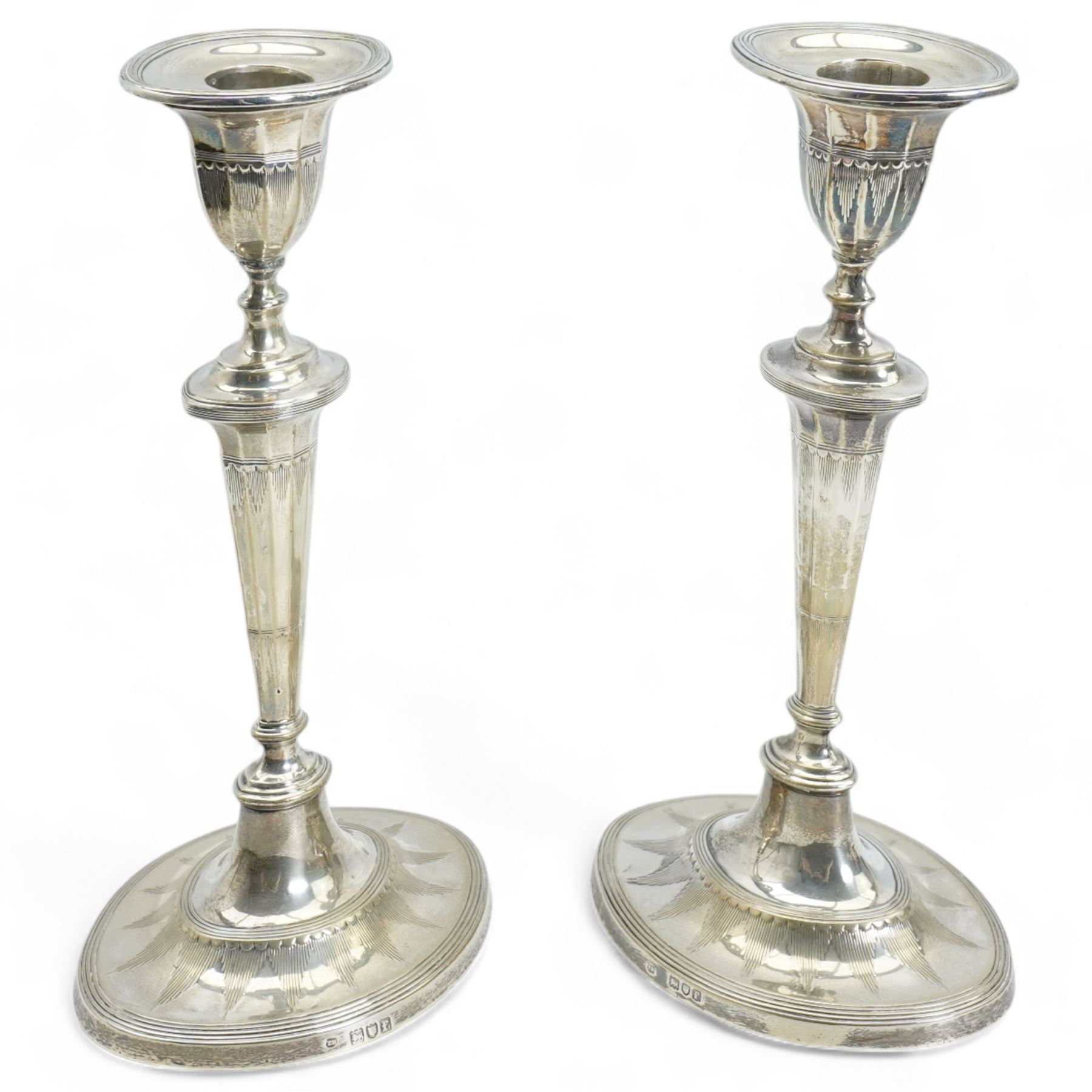 Pair of Edwardian silver table candlesticks with engraved tapering stems and oval bases H24cm London 1901 Maker Thomas Bradbury