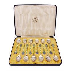 Set of twelve silver coffee spoons, each with enamelled blue flower to terminal and green and white enamel decoration to stem, hallmarked Mappin & Webb Ltd, Birmingham 1934, contained within fitted case