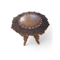 Carved Indian hardwood occasional table, the octagonal top carved with roses, upon a foldi...