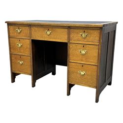 Edwardian oak twin pedestal desk, moulded rectangular top with inset writing surface, fitted with seven drawers, panelled sides, on stile supports 