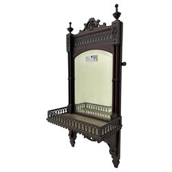 Early 20th century mahogany hall mirror with shelf, pierced pediment flanked by turned finials, the bevelled mirror plate enclosed by turned upright pillars, the shelf with fret work gallery, pierced lattice work lower panel 