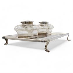 George V silver inkstand of rectangular design with pen tray and two cushion shape glass inkwells with silver covers, raised edge and four shaped supports 28cm x 20cm Birmingham 1912 Maker William Hutton & Sons