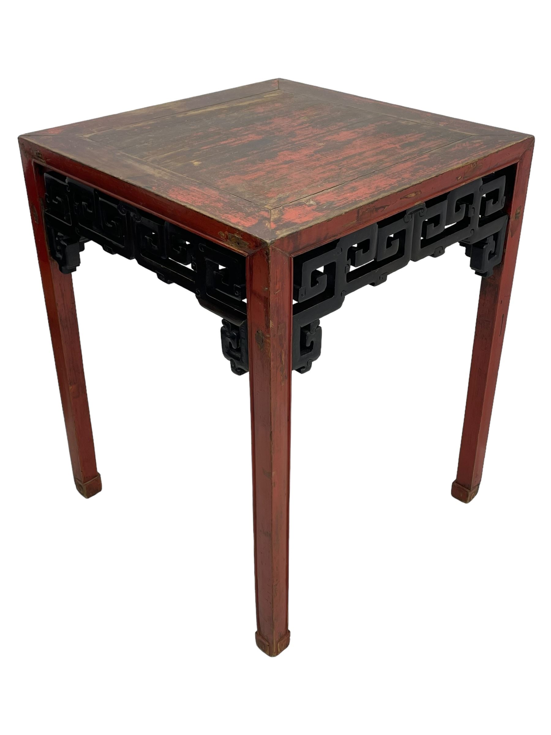 Late 19th century Chinese Qing dynasty red and black lacquered wood tall tea table, Shanxi region, square top over geometric scroll fretwork panels, on square supports with hoof feet 