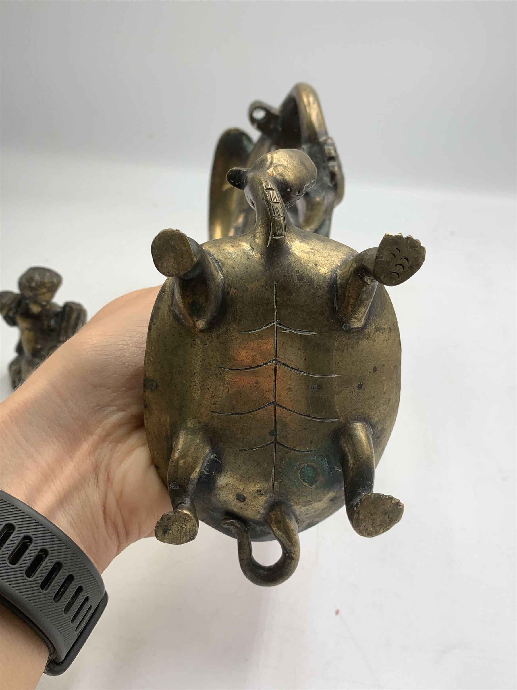 Early 20th century Japanese bronze figure or Okimono, modelled as a crane standing atop a turtle shell, possibly a candle holder, H25cm together with a small bronze figure modelled as a seated Cherub, H7cm (2)