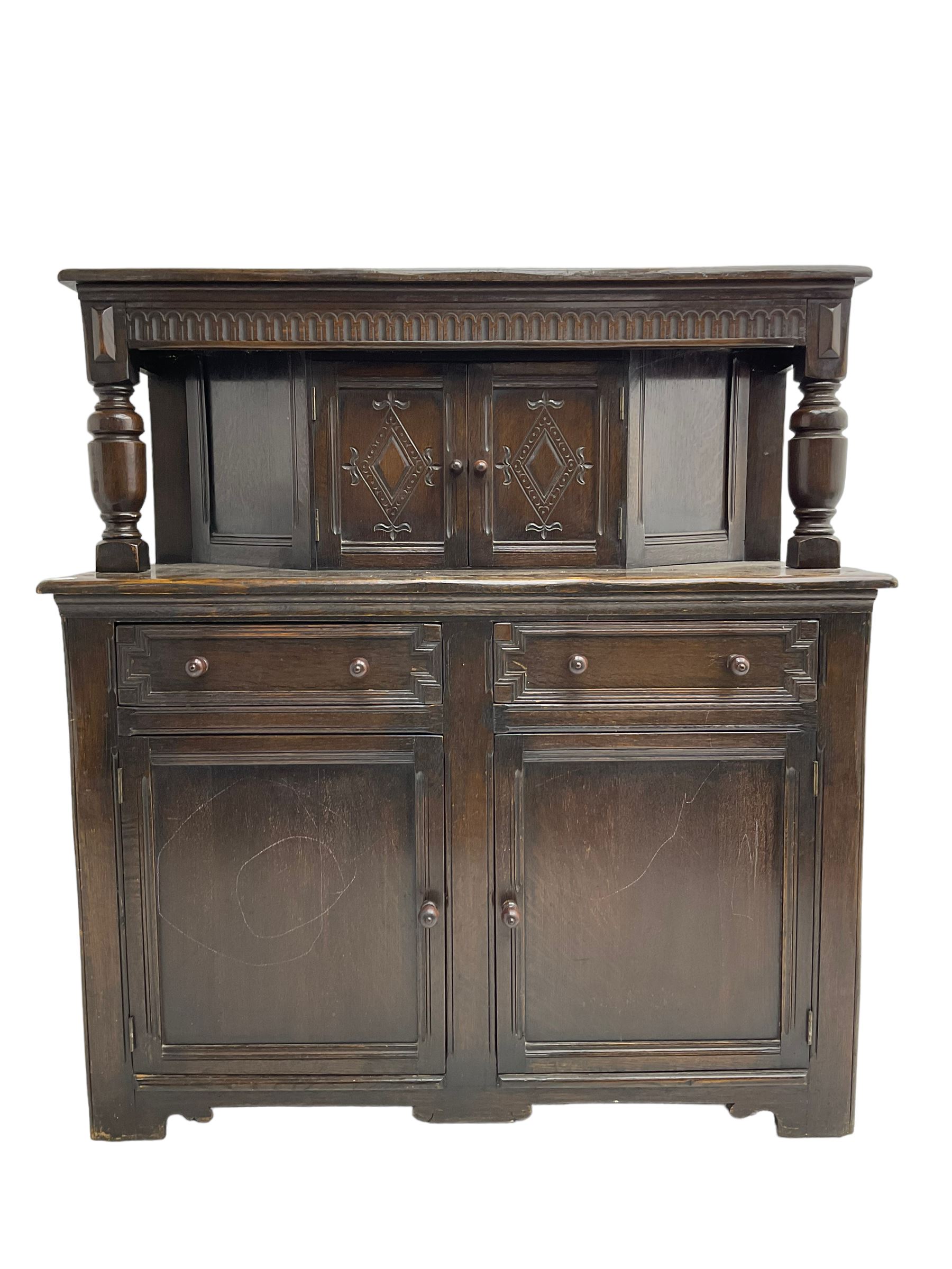 20th century oak court cupboard, arcade carved frieze over baluster supports with demi-hexagon cupboard with lozenge carved facias, the base fitted with two drawers over double cupboard, each with heavily moulded edges