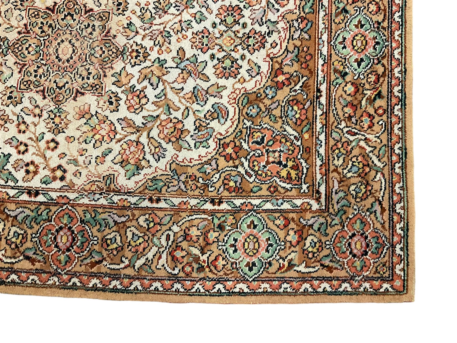 Large Persian design carpet, overall floral design, the field decorated with large rosette motifs surrounded by trailing foliate motifs, the border decorated with trailing branch and stylised plant motifs