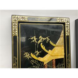 Two 20th century Chinese lacquered wall plaques, decorated in relief with female figures playing instruments beneath a pagoda, within gilt and mother of pearl inlaid borders, H92cm