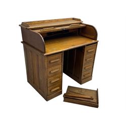 Early 20th century oak twin pedestal desk, tambour roll top enclosing fitted interior, eight drawers, on plinth base