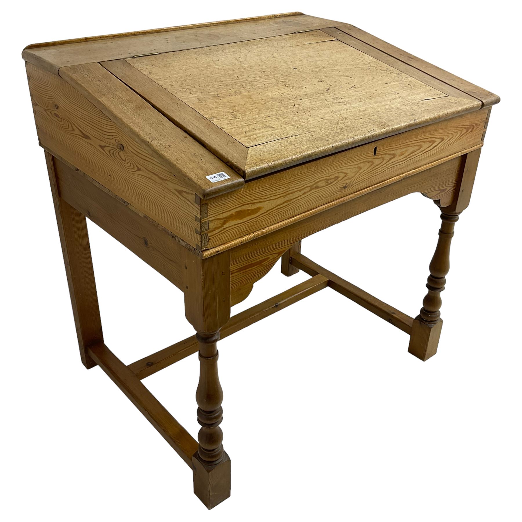 Early 20th century pitch pine clerk’s desk, stripped mahogany sloped hinged top, raised on turned supports