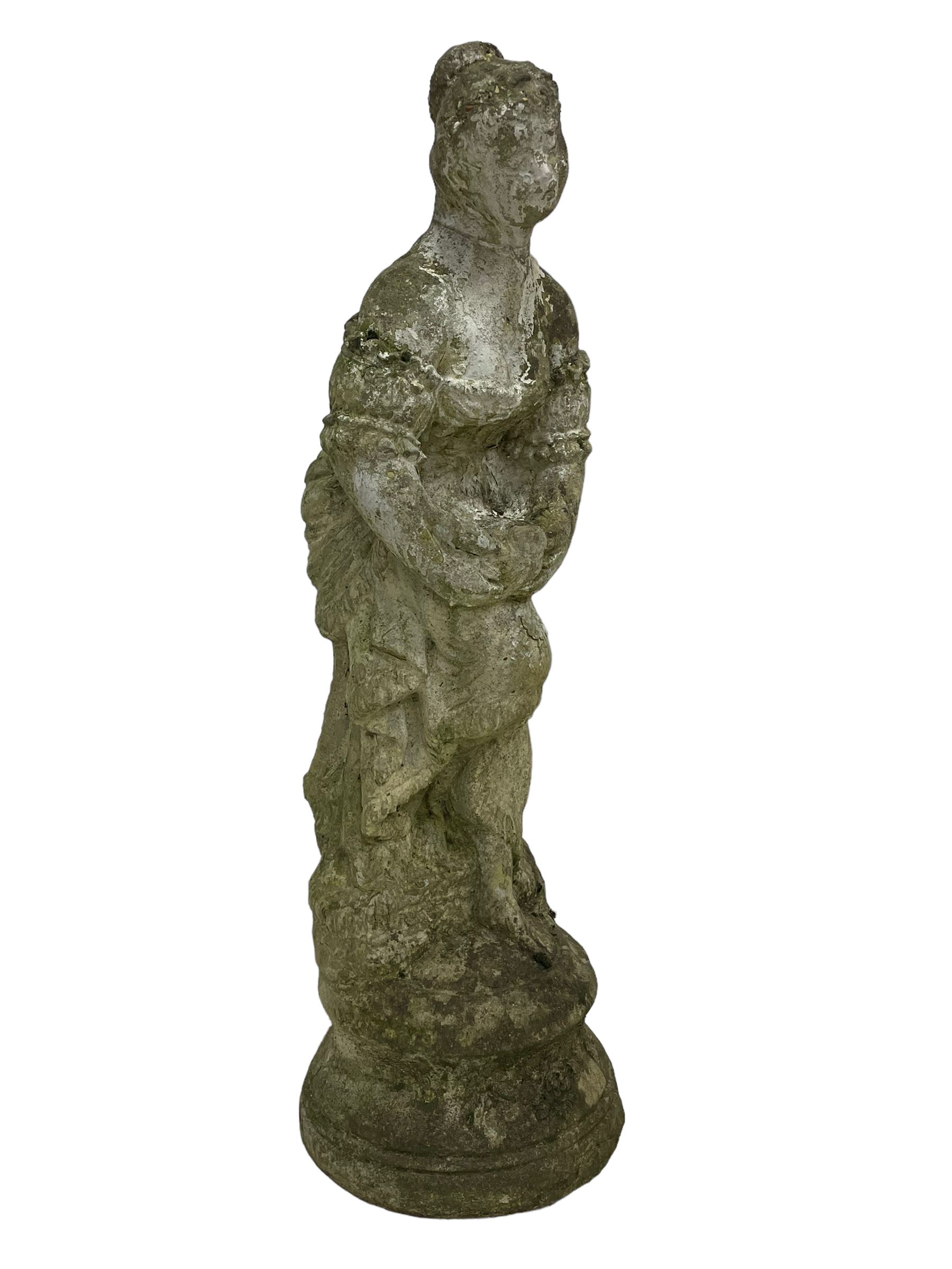 Weathered and painted cast stone garden statue, in the form of an Italian maiden with an ornate tied hairstyle and flowing gown, holding a wounded dove, on a turned base with garland decoration