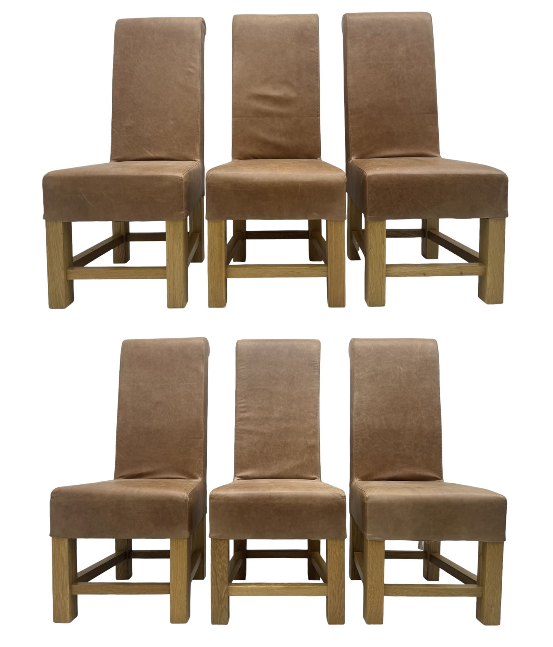 Set of six contemporary light oak dining chairs, each with high back and seat upholstered in pale tan leather, on square supports connected by H-stretcher