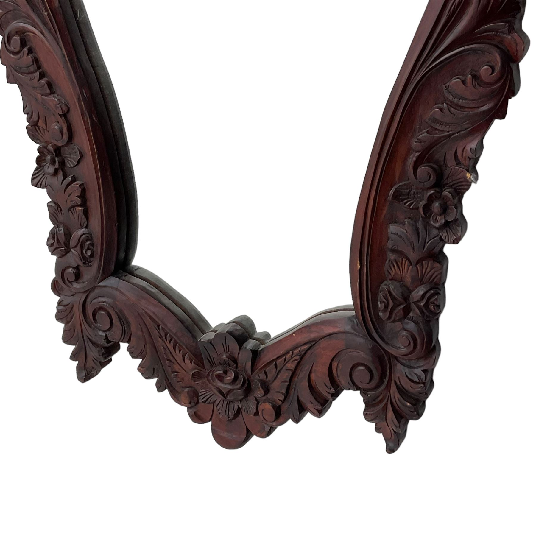 Pair of carved hardwood wall mirrors, shaped floral carved pediment over trailing and scrolled foliage decoration, plain mirror plate 