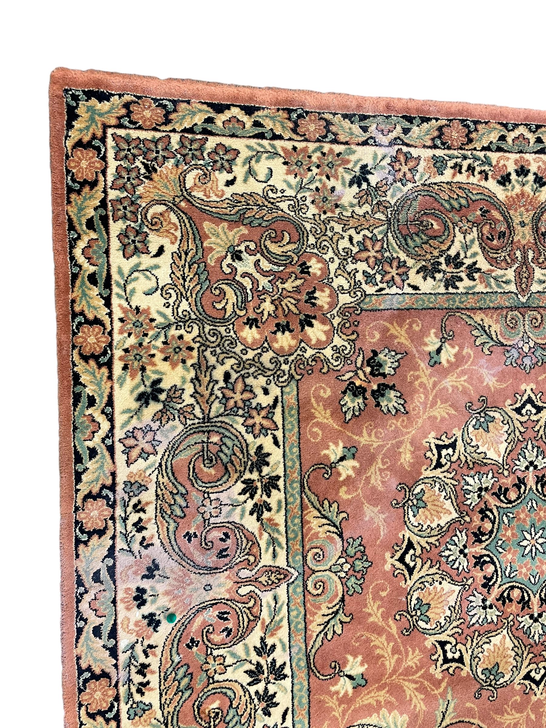 Persian design peach ground carpet, central floral medallion surrounded by scrolling foliage, decorated all over with stylised plant motifs, floral design repeating border