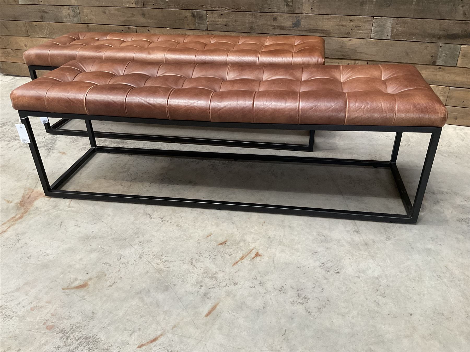 Two rectangular metal framed benches, upholstered in buttoned tan leather