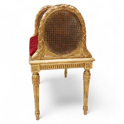 Late 19th century gilt wood and gesso window seat, raised oval cane work sides with lattice and ribbon decorated frame, rectangular cane work seat with upholstered squab cushion, moulded edge over fluted seat rails, on acanthus carved and stop-fluted turned supports 