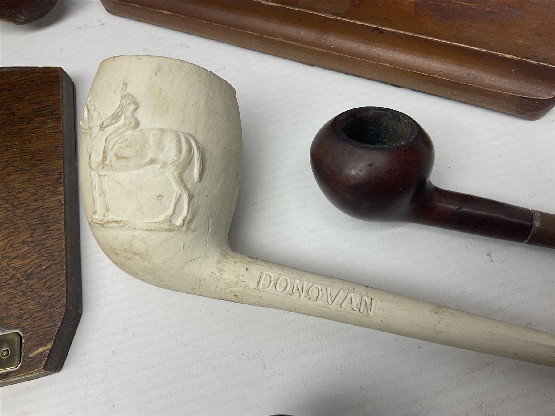 Collection of smoking pipes including Meerschaum pipe, carved as a female head, Briars and clay examples, etc and four pipe racks/stands