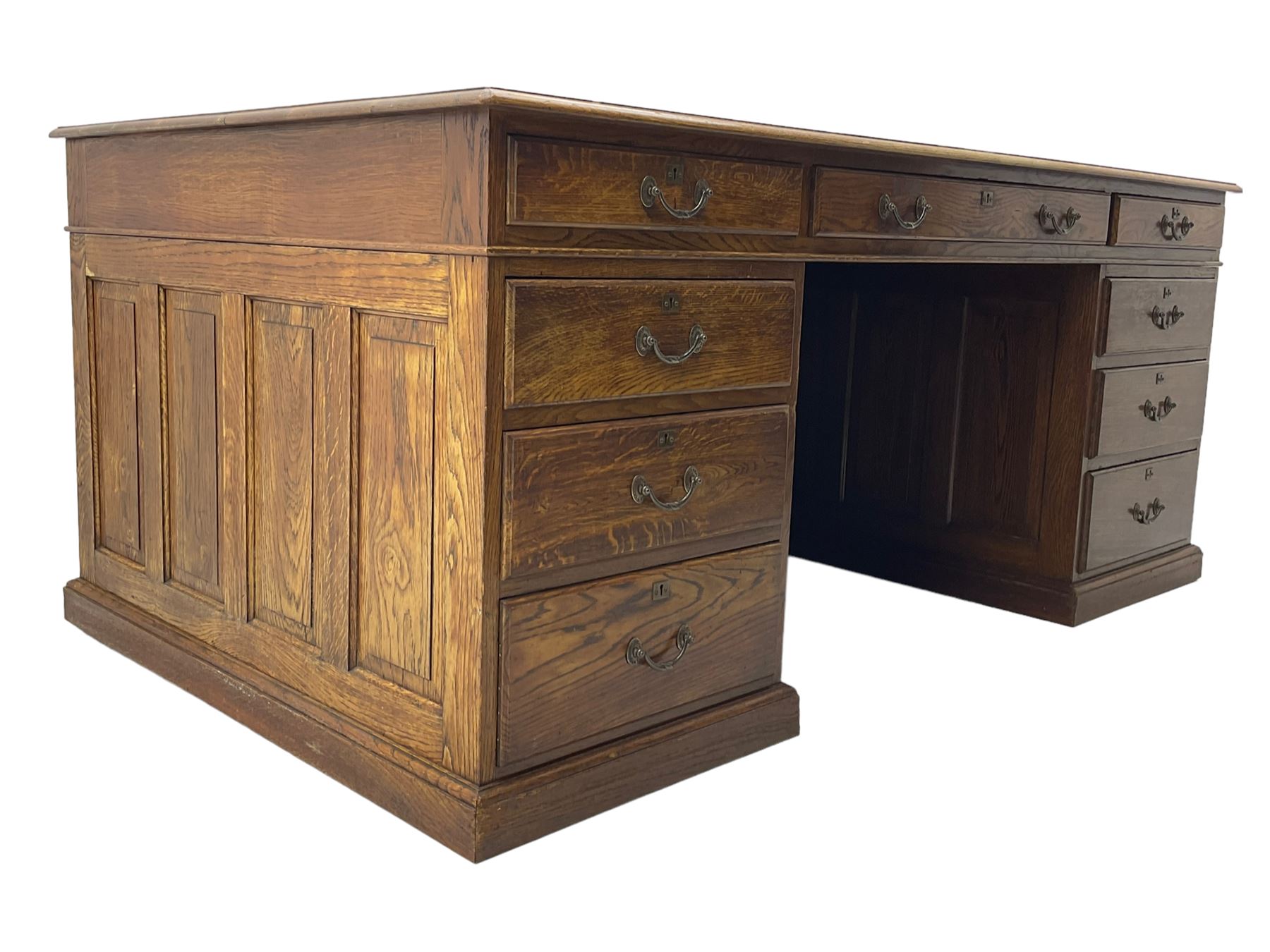 Large 20th century oak twin pedestal desk, moulded rectangular top over nine drawers, panelled pedestals, on moulded plinth base 