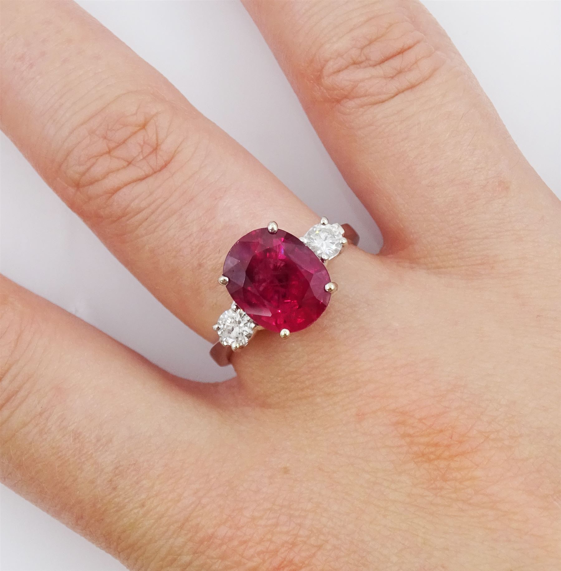 18ct white gold three stone oval cut ruby and round brilliant cut diamond ring, hallmarked, ruby approx 4.30 carat