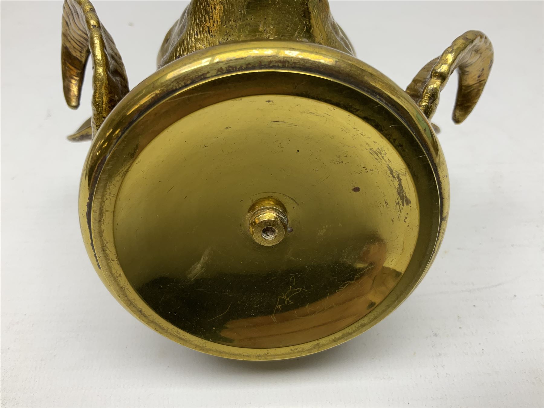 Brass figural inkwell, modelled as a ram's head, the hinged lid lifting to reveal interior with glass liner, raised upon circular spreading base, H11cm W14cm