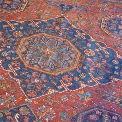 Old Persian red ground flat woven carpet, the field with three large medallions surrounded by small stylised flower head motifs, geometric border enclosed within running water band 346