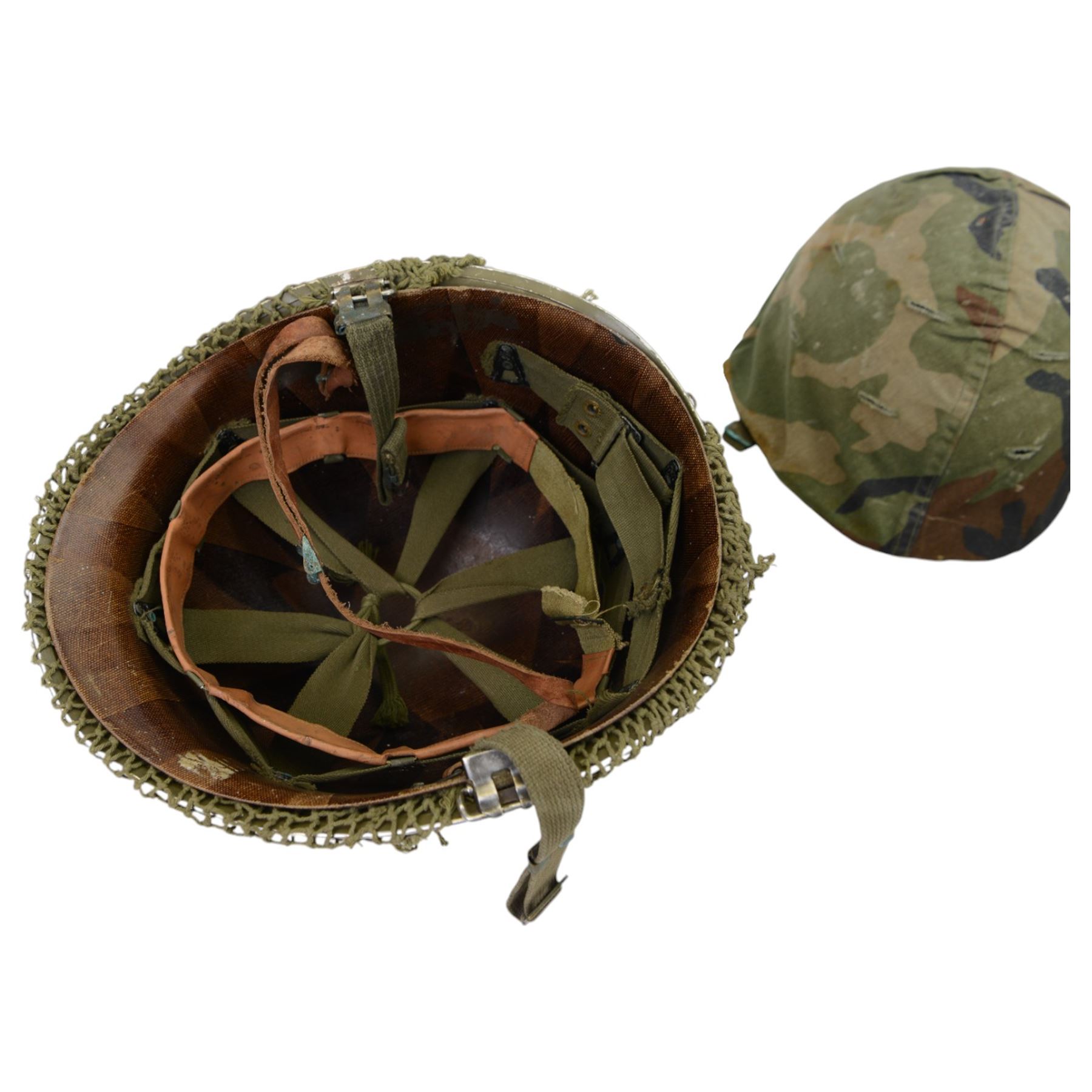 Collection of nine military helmets, including several with camouflage covering 