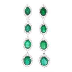 Pair of 18ct white gold graduating emerald and diamond pendant stud earrings, oval cut eme...