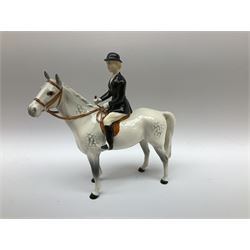 Beswick Hunting Group, comprising: two huntswoman on grey horses, model no 1730, huntsman on a bay horse, model no 1501, a seated fox, model no 1748, eighteen fox hounds and a spaniel, model no 967, all with printed marks beneath, together with three other ceramic huntsman on horseback and two hounds. 