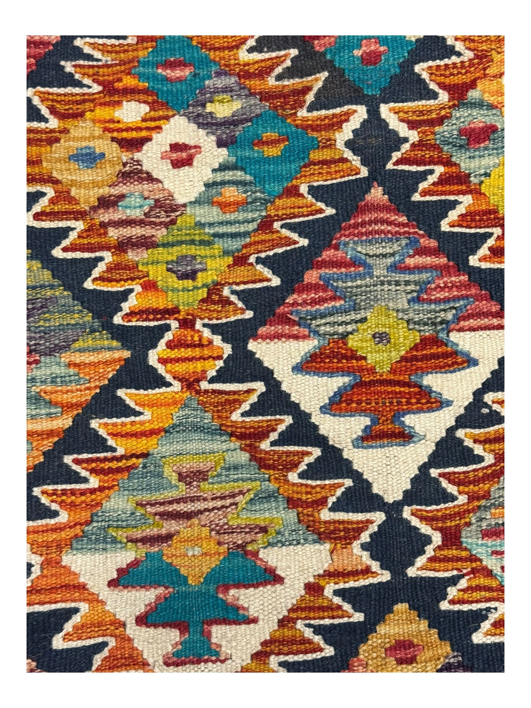 Chobi Kilim multicoloured ground runner, displaying diamond-shaped motifs in shades of blue, red, yellow, and green, accented by a bold black outline and bordered with a striped design, flatwoven with fringed edges