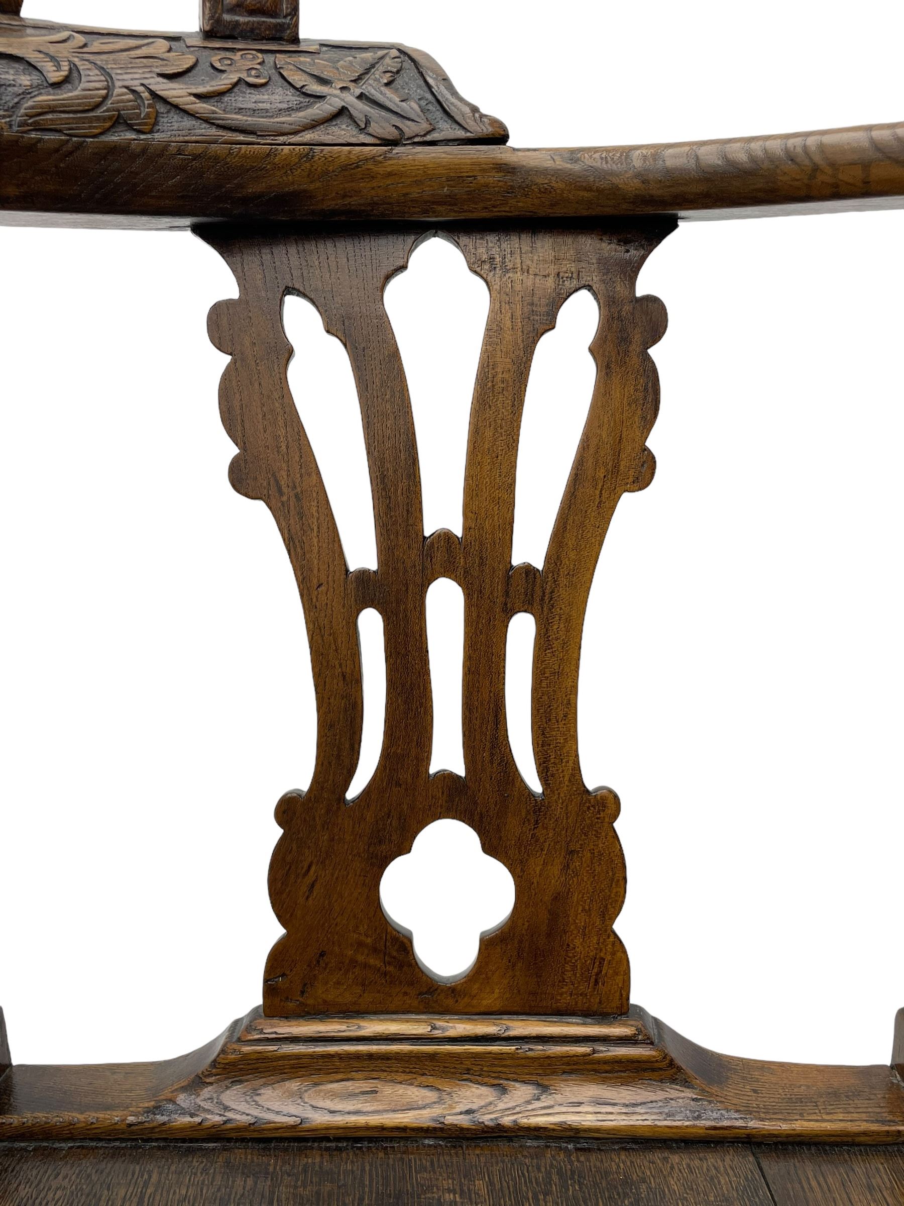 Elm 'Windsor' splat back corner armchair, shaped cresting rail carved with leaves over shaped and pierced splat, the curved arms carved with foliage and scrolled terminals, turned upper supports and a further two splats, panelled seat within foliate carved seat rails, on square rear supports with front shell carved cabriole support, united by plain x-frame stretchers