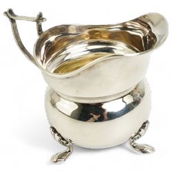  Victorian silver rectangular sugar basket with swing handle decorated with garlands and foliage on ball feet W15cm Sheffield 1891 Maker James Dixon & Son and a silver cream jug and sugar bowl Chester 1919 