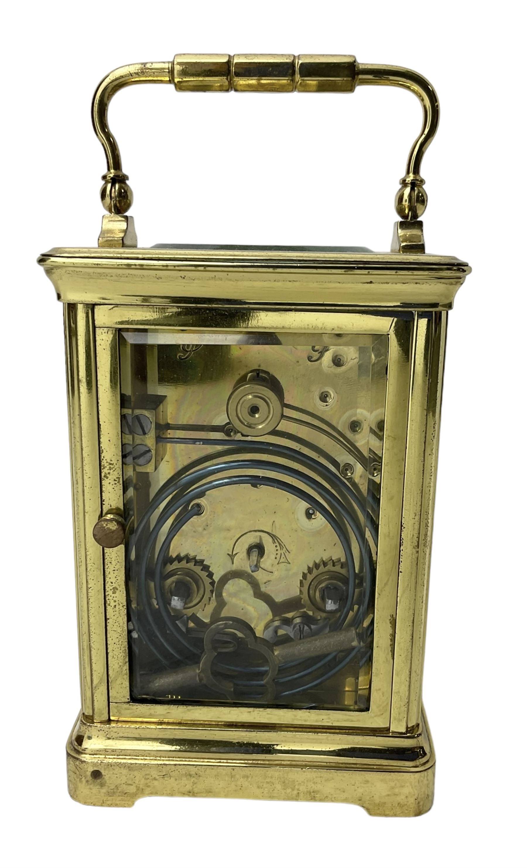 20th century -  8-day striking carriage clock in a corniche case, with an enamel dial , Roman numerals, minute track and steel spade hands, twin train going barrel movement with a lever platform escapement and rack striking, sounding the hours and half hours on a coiled gong.  With key.